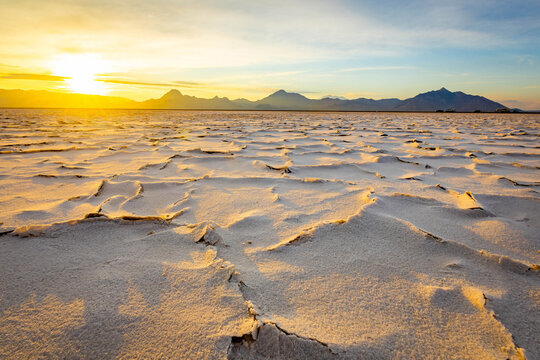 Golden sunrise illuminating textured crust at Bonneville Salt Flats Utah