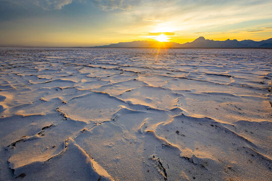 Golden sunset illuminating textured crust at Bonneville Salt Flats Utah