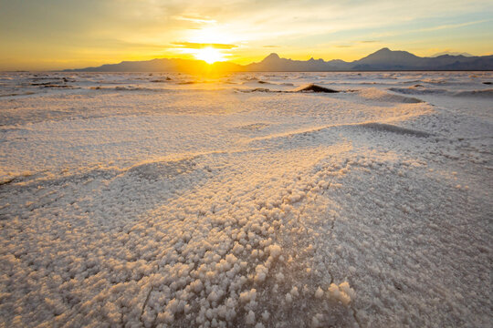 Golden sunset illuminating textured crust at Bonneville Salt Flats Utah