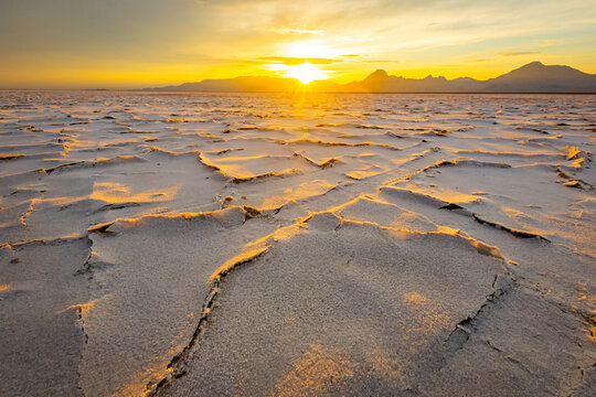 Golden sunset illuminating textured crust at Bonneville Salt Flats Utah