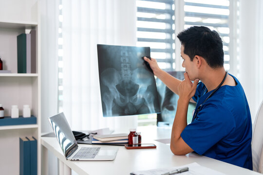 Doctor radiology  holding x-ray film , reviewing patient diagnosis results in clinic.