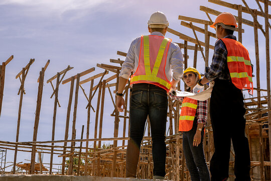 Civil engineer, architect and foreman worker with blueprints discuss, plan working for the outdoors building construction site. Construction collaboration concept