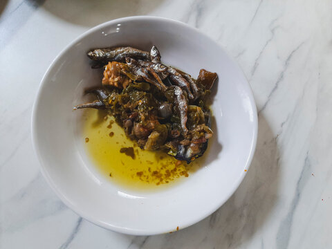 Sambal ijo with crispy fried anchovies or bilis, green chilies, shallots, garlic, and tempe served in a white bowl, a spicy traditional Minangkabau side dish in Padang restaurants local dish.