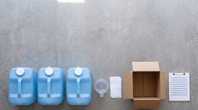emergency water storage preparation overhead sealed drinking water containers measuring cup blank labels cardboard box checklist for household disaster preparedness blue white gray