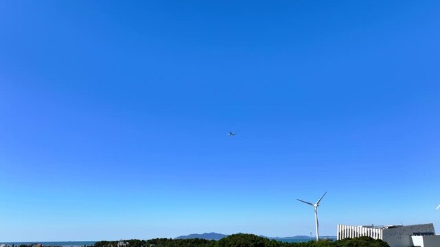 Cinematic 4K shot of a large passenger airplane flying through the blue sky