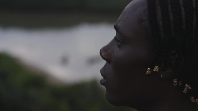 Close up side profile portrait of young black man in Ghanaian nature