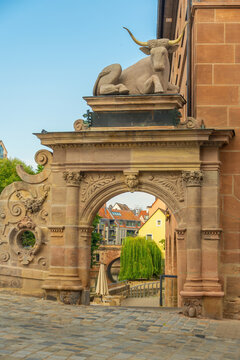 Close-up daytime view of the historic stone Ox Portal (Ochsenportal) with its ornate carved archway and stone ox statue overlooking the old town and Pegnitz River in Nuremberg