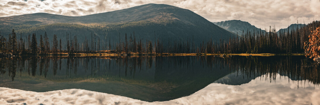 Mountain and cloud reflections across a panoramic lake