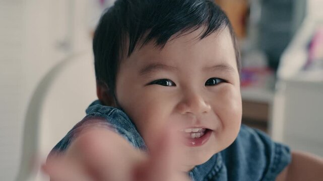 Cute Asian baby boy smiling happily and reaching hand towards camera.4K	