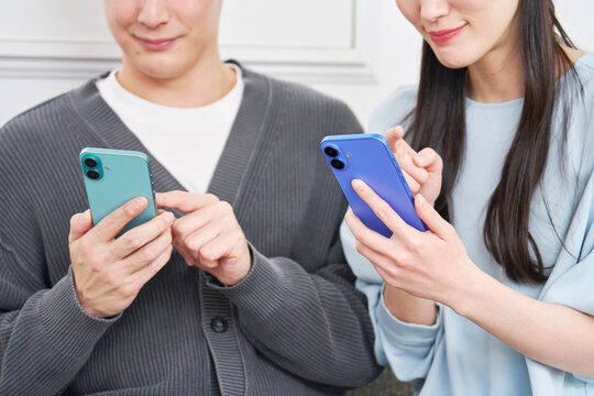 リビングでスマホを使っているカップル　顔無し