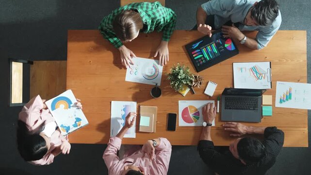 Top down view of businesswoman explain and present financial chart. Diverse group discuss and listening presentation about stock market statistic at meeting table with investment graph. Convocation.