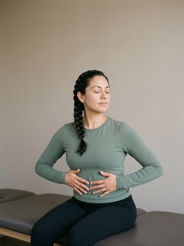 Postpartum Woman Practicing Diaphragmatic Breathing in Clinic