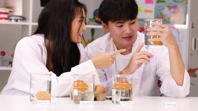 Teenage Students in Lab Coats Conducting Science Experiment with Beakers