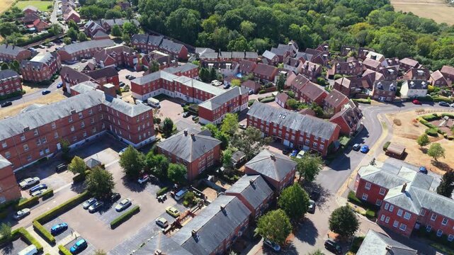 Aerial drone view of Knowle Village near Fareham, Hampshire, featuring converted Victorian red-brick former hospital buildings and modern residential housing surrounded by green fields.