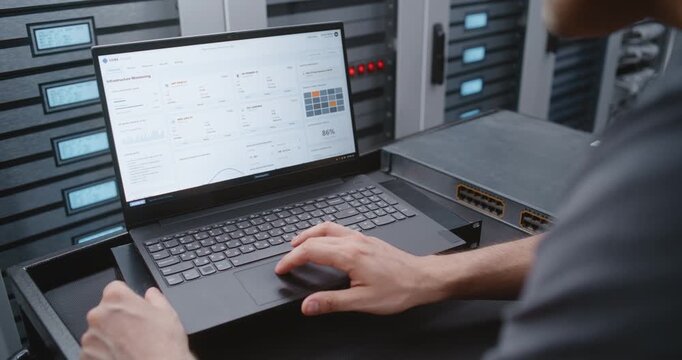 Male IT Engineer Handles DDoS Alert Using Linux Command Line, Reviewing Network Conditions and Performing Emergency Troubleshooting While Monitoring Critical Data Center Systems in Real Time.