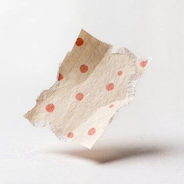 Torn handmade paper scrap with red polka dot pattern floating on white, craft collage and scrapbook design element concept with copy space for text