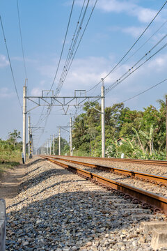 Double track railway with overhead electric catenary poles extending into the distance