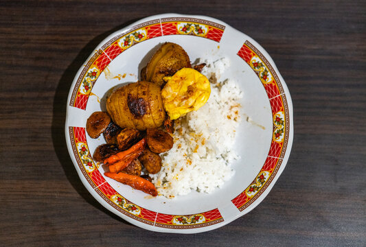 Indonesian traditional rice dish with fried egg, potatoes, and chili peppers
