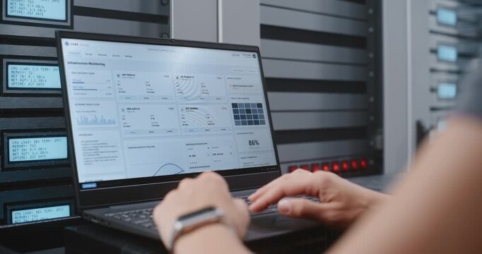 Female Cybersecurity Specialist Investigates DDoS Attack Through Terminal Interface, Monitoring Server Activity and Applying Emergency CLI Procedures inside Modern High Density Data Center Facility.