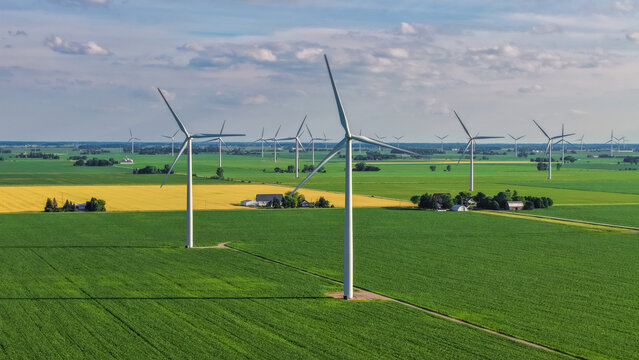 Wind turbines generating clean energy in vast green fields in Michigan