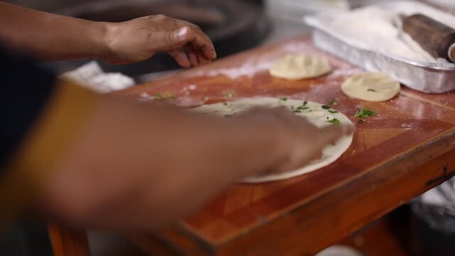 Hands Kneading and Preparing Garlic Naan Dough on Wooden Table