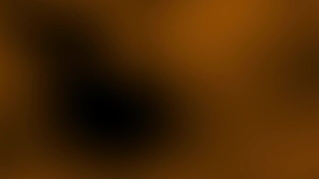 Blurred abstract image featuring a dark and orange gradient with soft transitions, creating a warm and mysterious atmosphere.