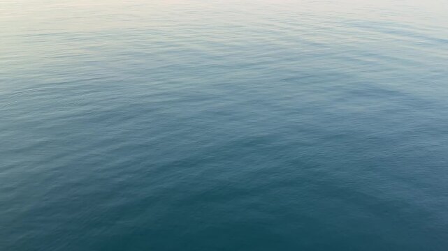Gentle ripples on a calm sea blue water surface.