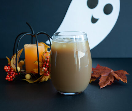 Glass Cup of Coffee with Halloween Ghost and Autumn Leaves