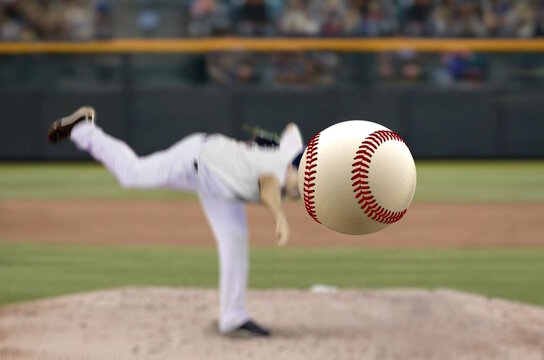 Baseball pitcher on the mound throwing a high-speed ball from a batter perspective.