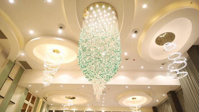 Modern crystal chandelier hanging from a decorative ceiling in a Delhi venue