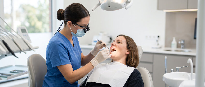 Dental hygienist performing routine professional teeth cleaning