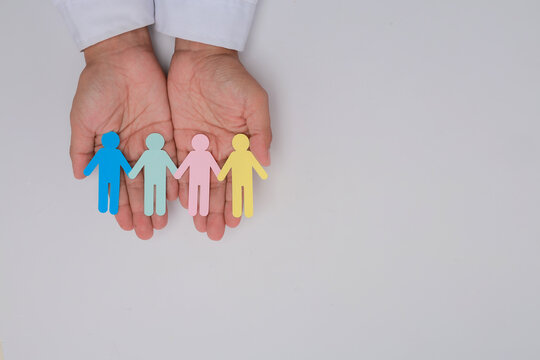 Caring hands holding paper figure chain show hopeful support for intergenerational community care and peaceful family unity