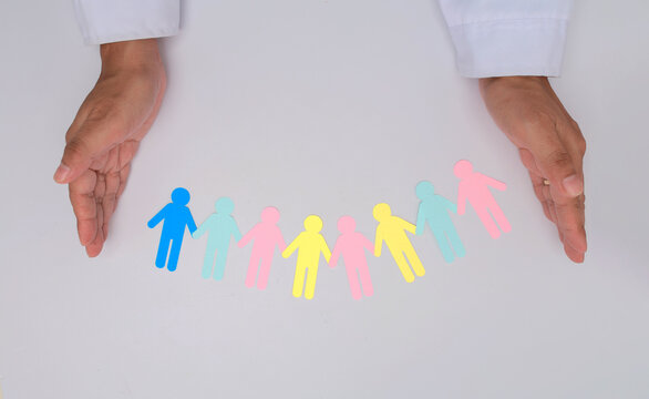 Hands protect paper cutout figures with care and empathy to promote intergenerational community bonding and social support