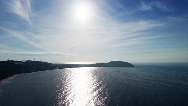 Bright sunlight reflects on the water at Xuan Thuy in Mui Ne, Lam Dong. The camera captures the coastline and the waves gently rolling onto the shore. Enjoy the clear skies and the view.