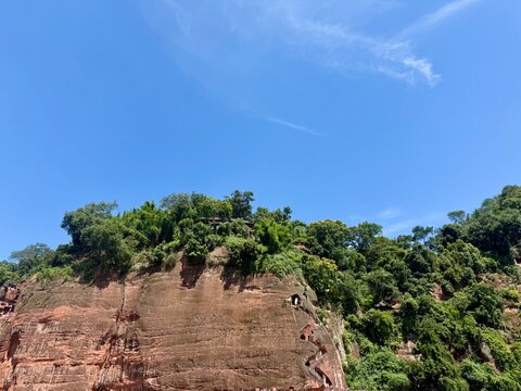 Red sandstone cliff under a blue sky near Leshan Giant Buddha, China