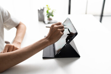 Using stylus on tablet for digital note taking and productivity technology concept. © Charlie's