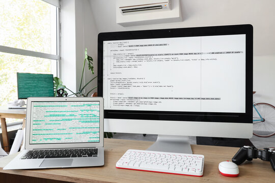 Software development and programming, computer screens with php code on a desk in a modern home office for remote work and freelance web engineering