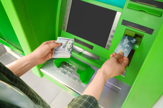 Personal finance and banking, person withdrawing cash from an atm with a credit card for financial transactions and money management in a public area