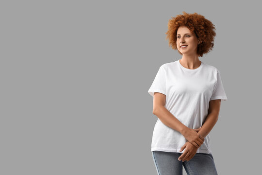 Diversity and inclusion, confident woman with curly hair wearing a blank white t-shirt for branding mockup isolated on a solid grey background