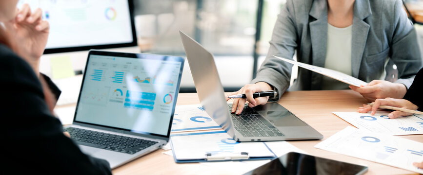 Close Up Businesspeople Hands Working on Laptops and Reviewing Financial Documents