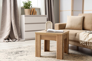Mindfulness and relaxation, open book on wooden table in cozy living room interior with beige sofa and home decor for peaceful lifestyle atmosphere © Pixel-Shot