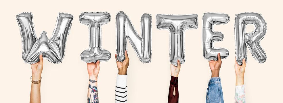Hands holding balloons spelling Winter