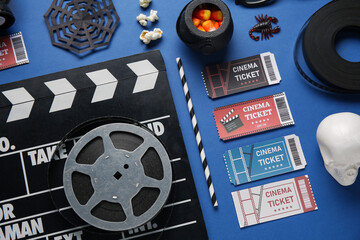 Obraz premium Composition with clapperboard, cinema tickets, film reels and Halloween decorations on blue background