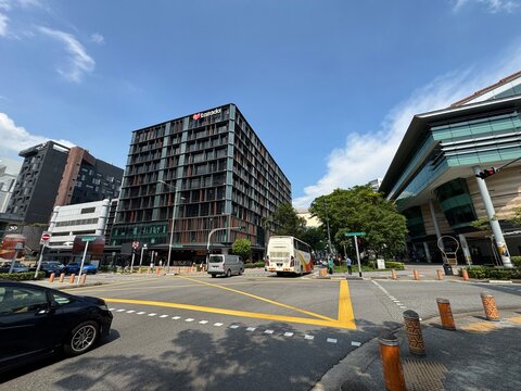 Singapore. April 25, 2025: Traffic at a busy city intersection in downtown Singapore with the Lazada One building in the background.
