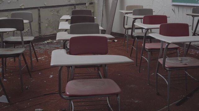 Ruined school classroom containing old dusty student desks peeling paint and scattered debris representing urban decay destruction and neglected history