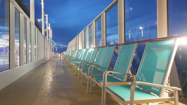 Empty Teal Lounge Chairs on Cruise Ship Promenade Deck at Night