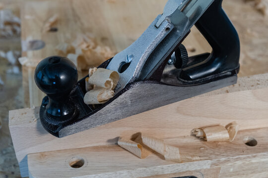 Close-up of a traditional hand plane producing wood shavings
