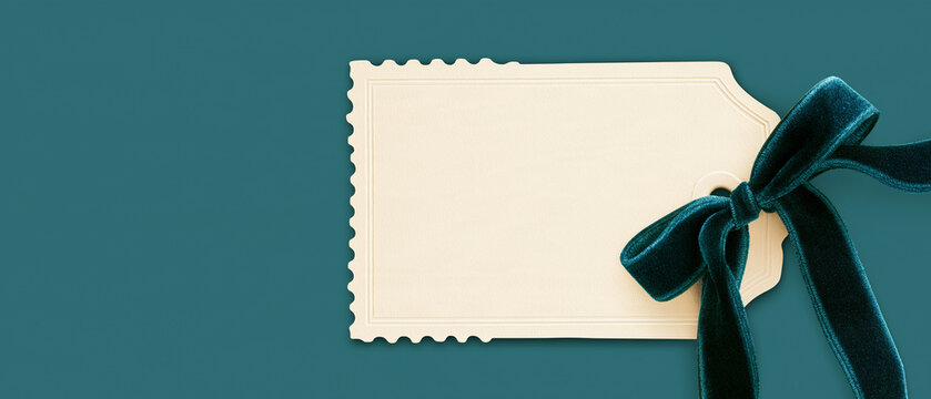 Gift Tag with Teal Ribbon: A blank, decorative gift tag with a sawtooth edge is tied with a rich teal velvet ribbon and bow, presented against a solid, deep teal background.