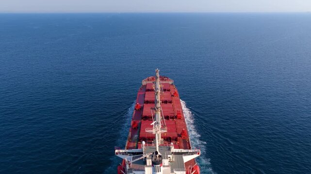 Aerial captains POV view of the bow of a general cargo ship traveling over the ocean