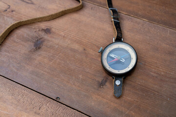 A compass and map rest on a rustic table. Travel gear suggests navigation, exploration, and adventure. The composition supports tourism, journey, and discovery themes. © Svetliy